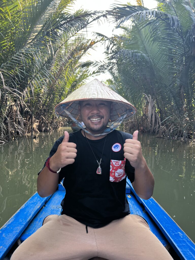 Quest With Qui Riding in a Canal with a Vietnamese Hat